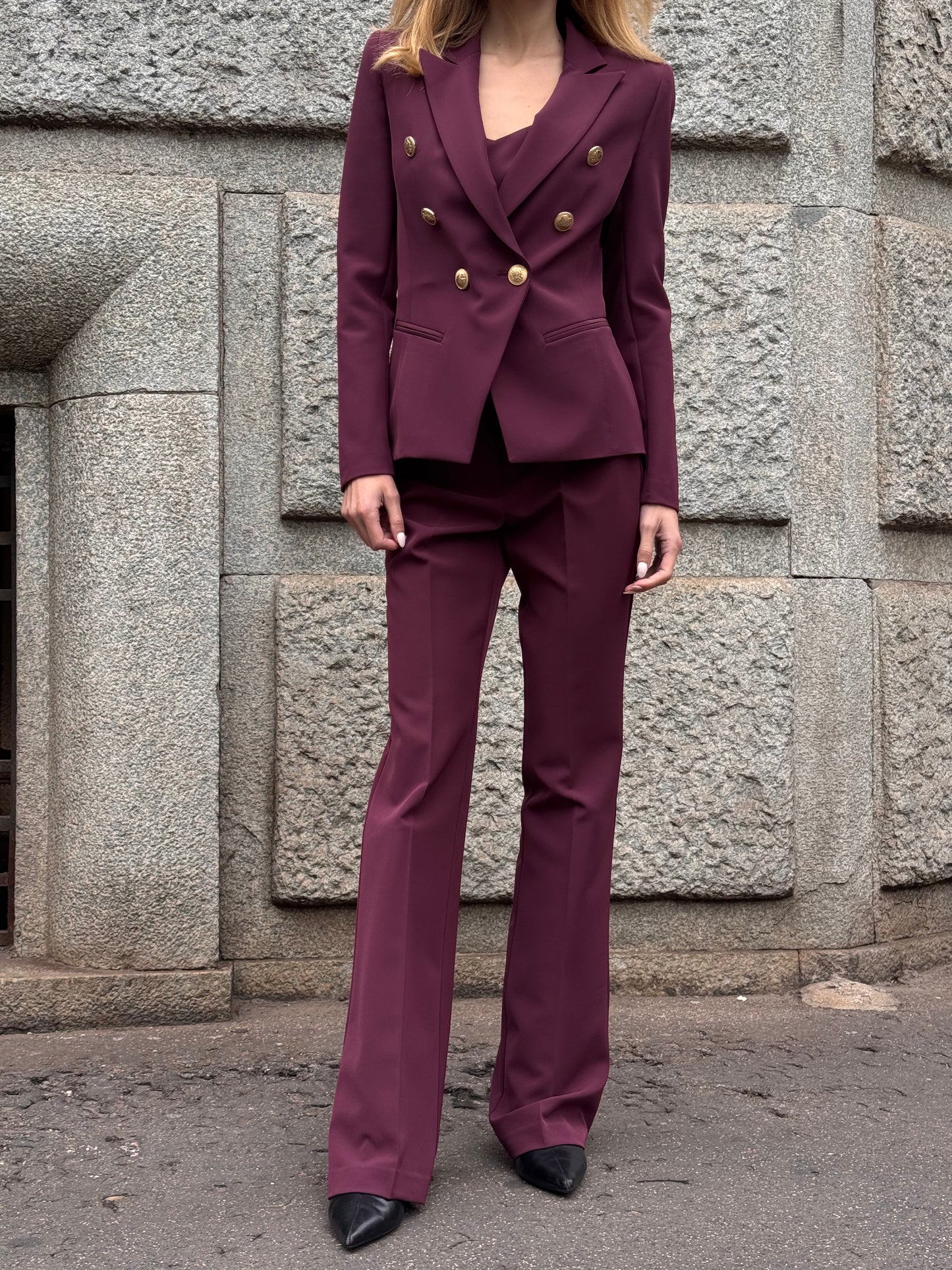 Tailleur melanzana con bottoni dorati e pantalone a zampa