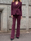 Tailleur melanzana con bottoni dorati e pantalone a zampa