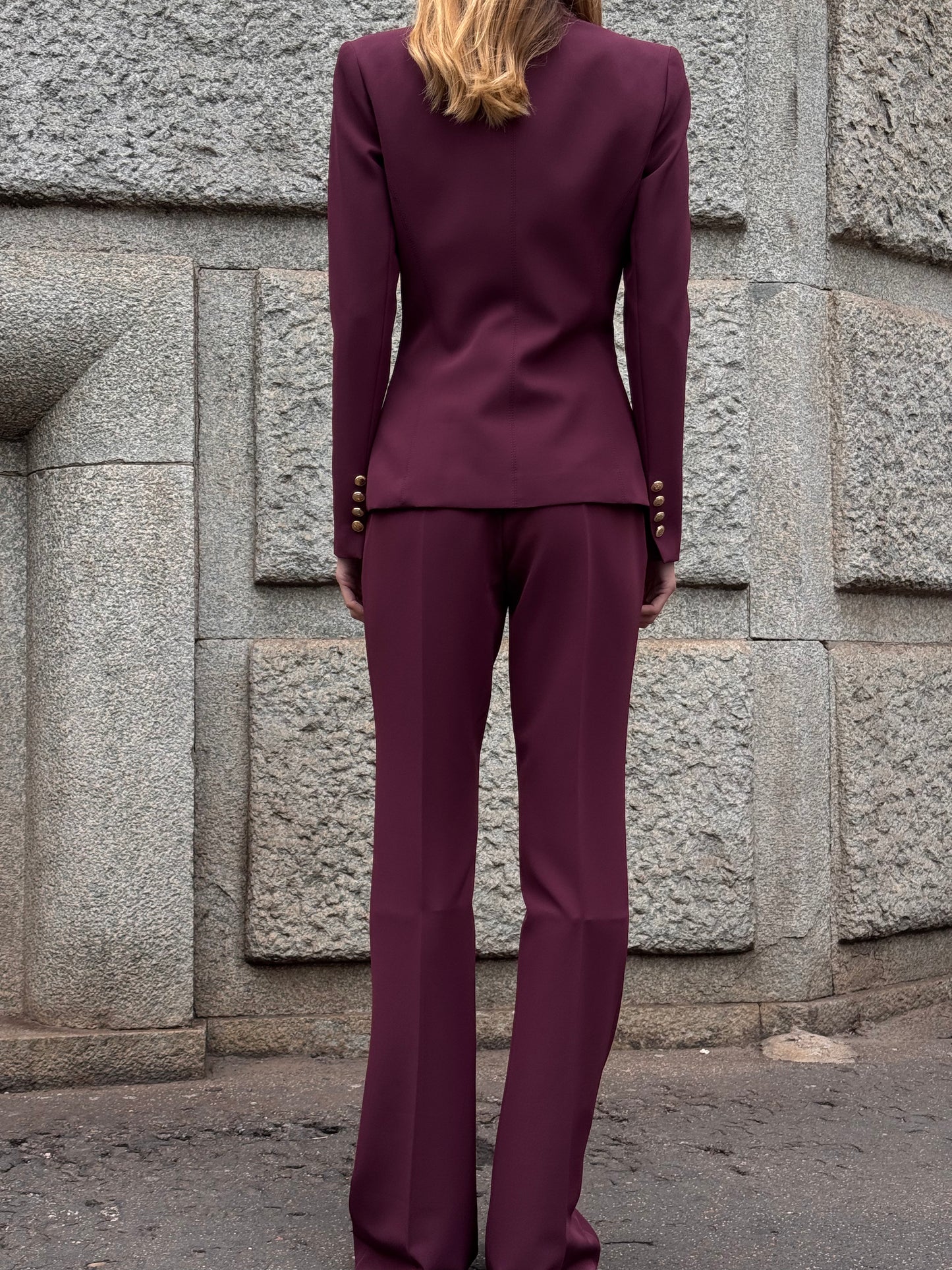 Tailleur melanzana con bottoni dorati e pantalone a zampa
