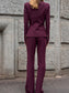 Tailleur melanzana con bottoni dorati e pantalone a zampa
