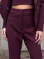 Tailleur melanzana con bottoni dorati e pantalone a zampa